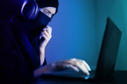 A female Arab social engineer behind a laptop. 