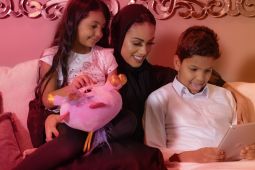 A mother and her children using a laptop.