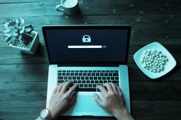 Hands of a person using a laptop that needs a password to login.
