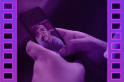 Hands holding a smartphone that is showing a selfie of someone.
