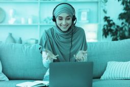 امرأة ترتدي الحجاب وتجري مكالمة فيديو على الكمبيوتر المحمول.