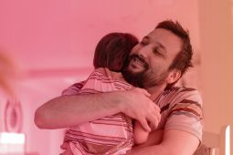 A father hugging his son.