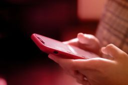 Hands of a kid using a smartphone. 