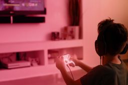  طفل يحمل وحدة تحكم لأنه يلعب ألعاب الفيديو.