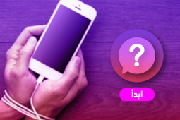 أيادي شخص مقيدة بسلك الشاحن الخاص بهاتفه الذكي