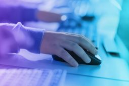 Hand of a child holding the mouse of a computer.